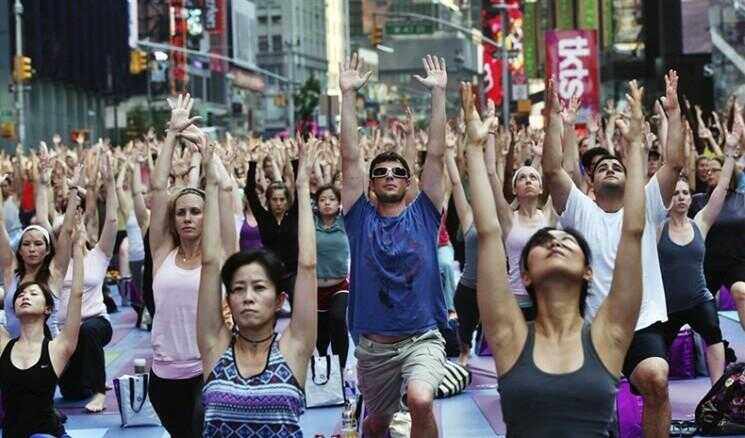 Des milliers effectuer le yoga à Times Square à New York
